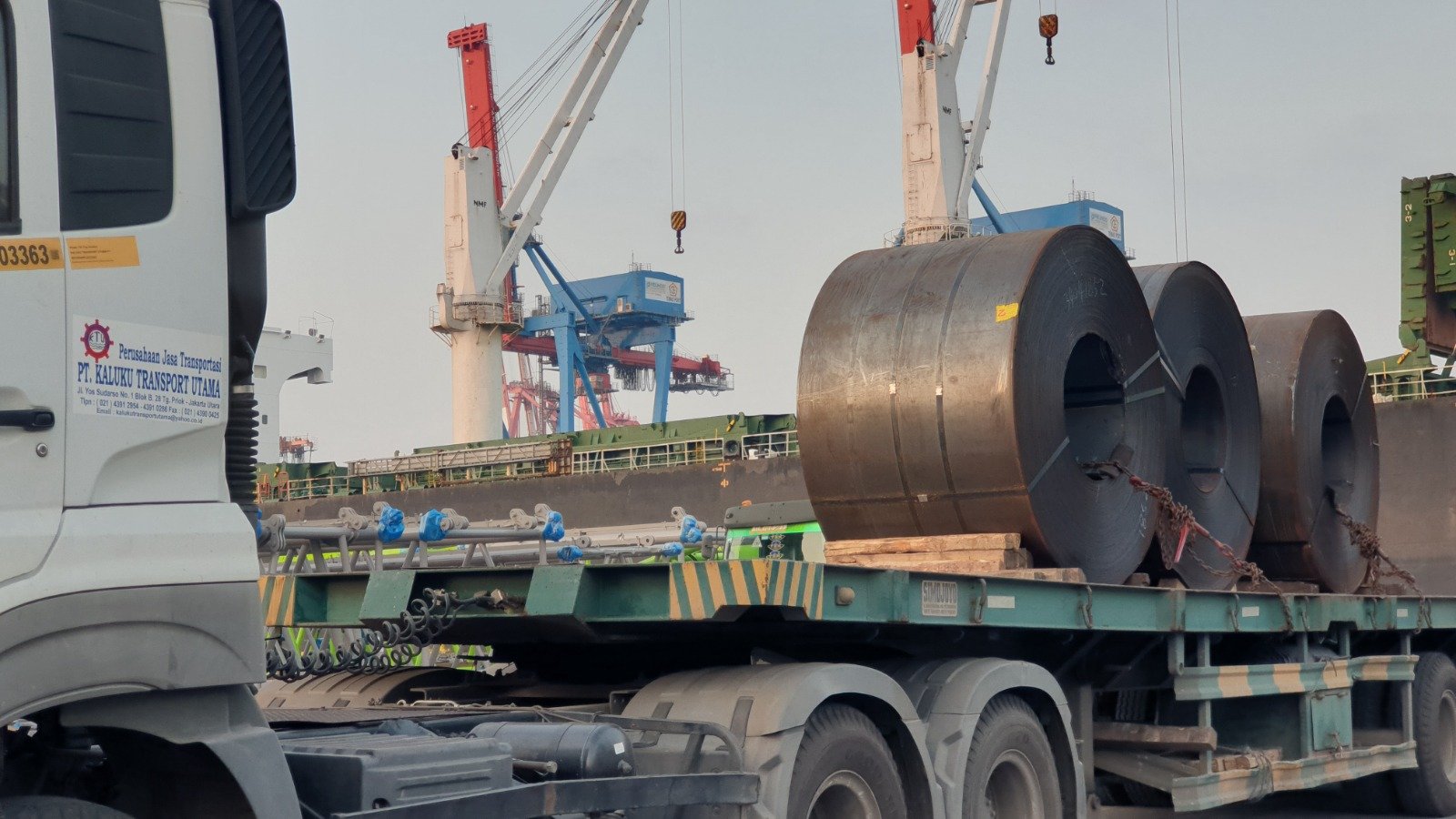 Truk Fuso Canter di jalan tol dengan latar belakang perkotaan