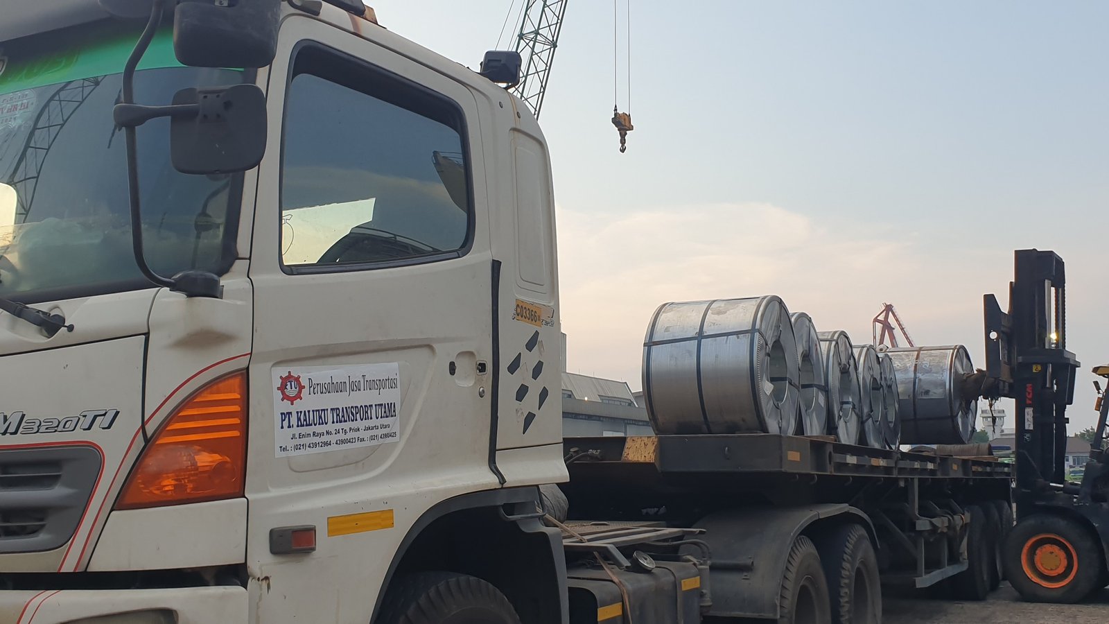 Truk Fuso Canter di jalan tol dengan latar belakang perkotaan